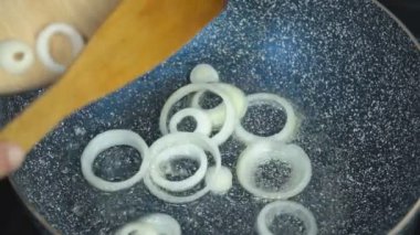bir tavada soğan dilimleri kızartma