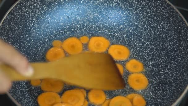 A sárgarépa szeletekre egy serpenyőben sütjük — Stock videók