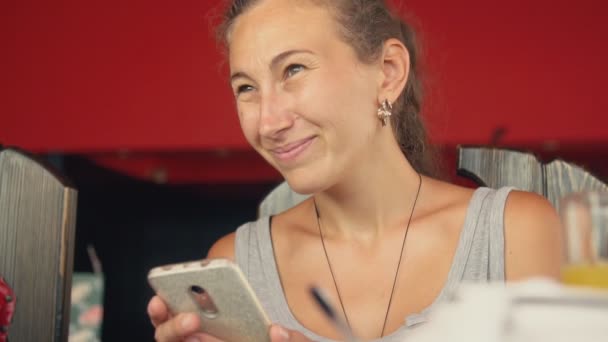 Женщина разговаривает с кем-то, глядя на телефон — стоковое видео