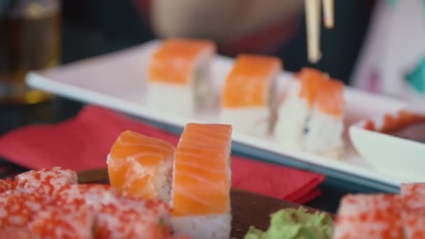 Chica toma sushi con palillos — Vídeo de stock