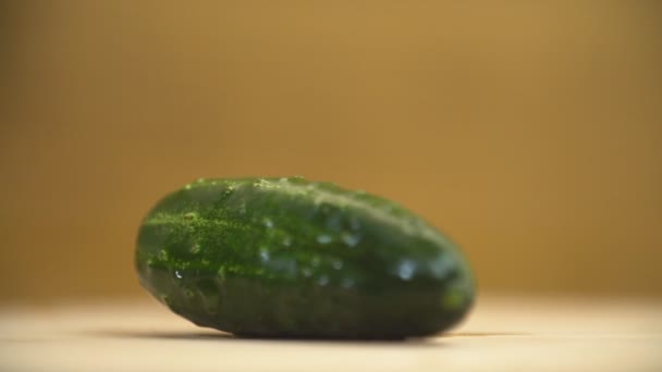 Een komkommer op een houten tafel — Stockvideo