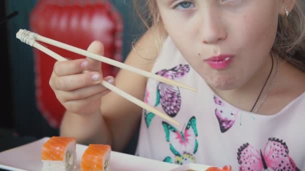 Klein meisje eten sushi — Stockvideo