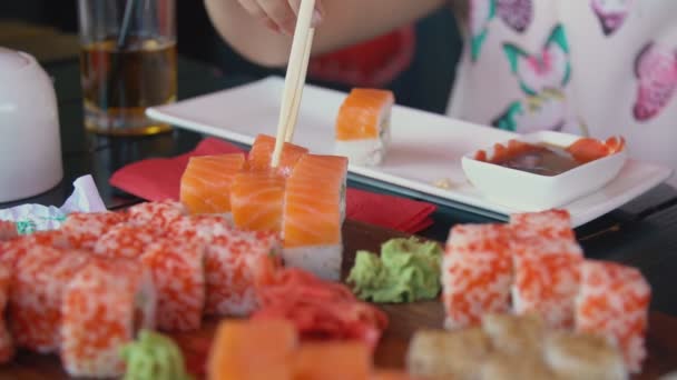 Meisje neemt Sushi met eetstokjes — Stockvideo