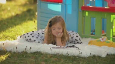 küçük kız bir battaniye üzerinde yatıyor