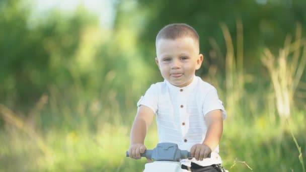 Jongen rijden een speelgoed motorfiets — Stockvideo