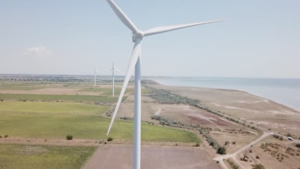 Parques eólicos en el fondo del campo y el mar — Vídeo de stock