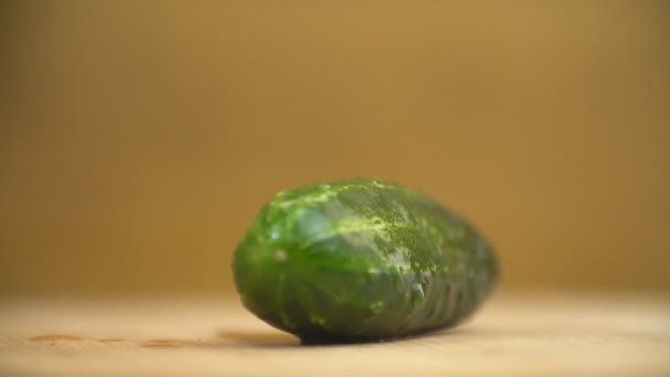 Un pepino sobre una mesa de madera — Vídeos de Stock