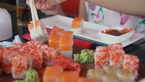 Chica toma sushi con palillos — Vídeos de Stock