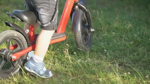 Хлопчик їде на велосипеді без педалей — стокове відео