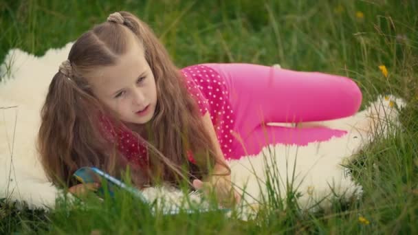 Маленька дівчинка читає книжку — стокове відео