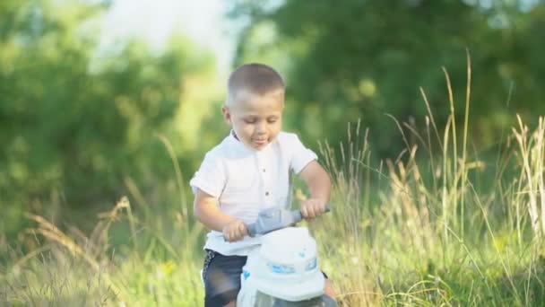 Jongen rijden een speelgoed motorfiets — Stockvideo