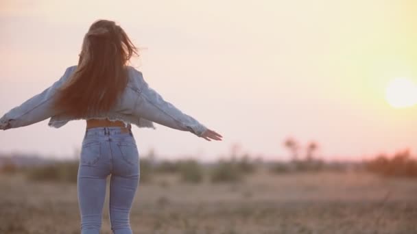 Chica en jeans ropa contra el sol poniente — Vídeo de stock