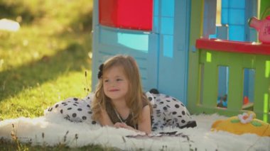 küçük kız bir battaniye üzerinde yatıyor