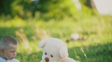 küçük çocuk oyuncak ayılar ile bir battaniye üzerinde oturan