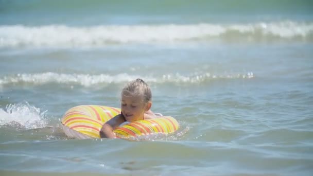 Девушка с надувным кругом купается в море — стоковое видео