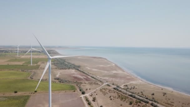 Parques eólicos en el fondo del campo y el mar — Vídeos de Stock