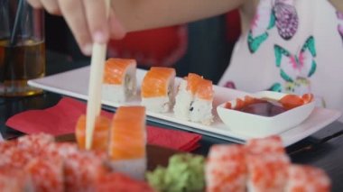 kız yemek çubukları ile suşi alır