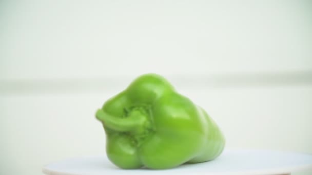 Grön paprika på en vit bakgrund — Stockvideo