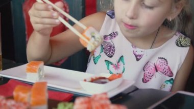 küçük kız yemek çubukları ile suşi yeme