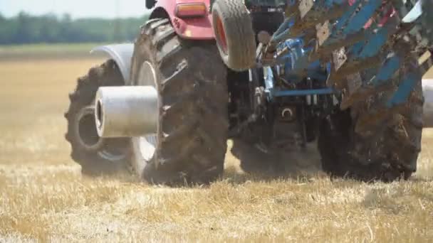 Traktor orki na ziemi z nowoczesnymi pługą — Wideo stockowe