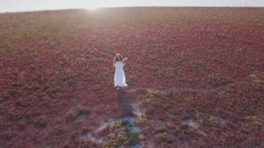 beyaz elbiseli kız deniz kıyısında yürür