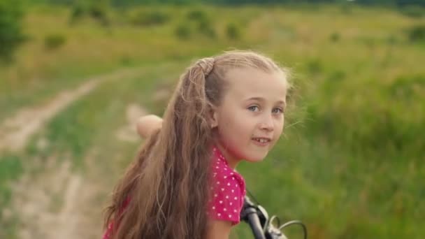 Flicka med långt hår rider en cykel — Stockvideo