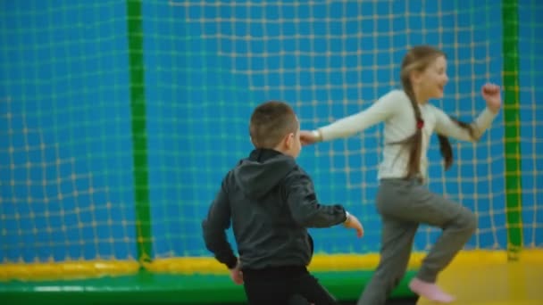 Kinder spielen Aufholjagd auf Trampolinen — Stockvideo