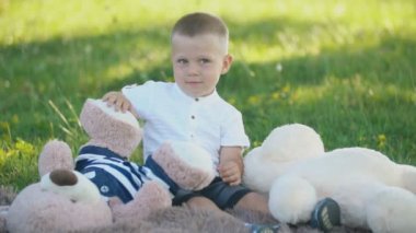 yumuşak oyuncaklar bir battaniye üzerinde oturan çocuk