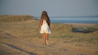 denize yakın yürüyen küçük kız