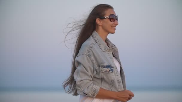 Chica en jeans ropa sobre un fondo del mar — Vídeos de Stock