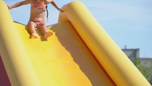 Little girl descends from a large water slide — Stock Video