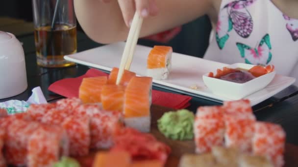 Niña comiendo sushi con palillos — Vídeo de stock