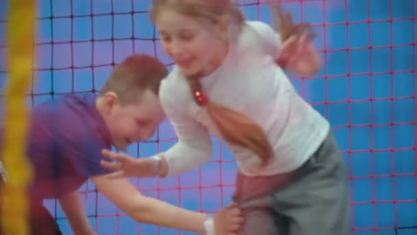 Kinderen spelen catch-up op trampolines — Stockvideo