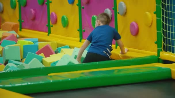 Jongen klimt een trampoline en valt — Stockvideo