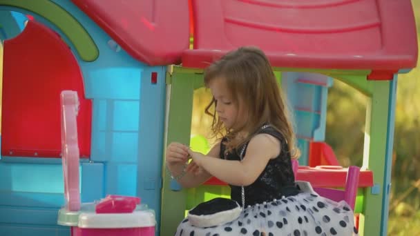 Маленькая девочка примеряет ринглет — стоковое видео