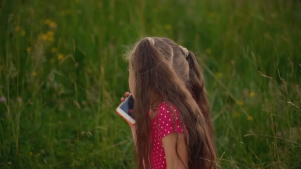Маленькая девочка разговаривает по телефону — стоковое видео