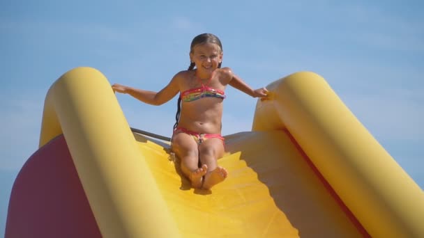 Klein meisje daalt van een grote glijbaan — Stockvideo