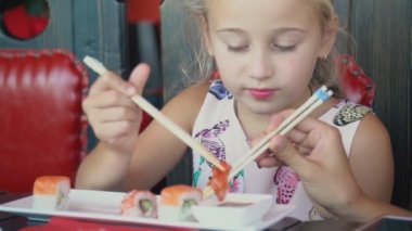 küçük kız yemek çubukları ile suşi yeme