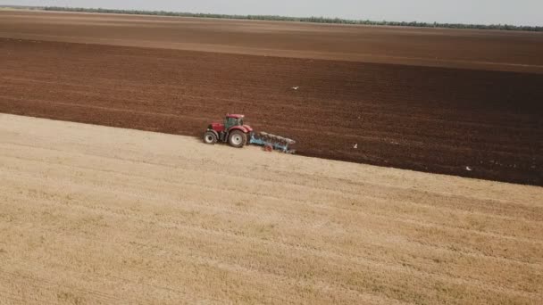 Трактор вспахивает землю — стоковое видео
