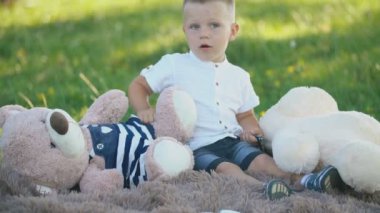 yumuşak oyuncaklar bir battaniye üzerinde oturan çocuk