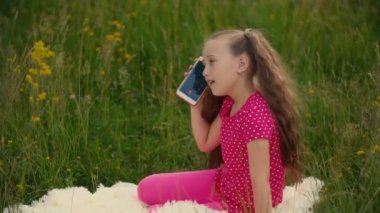 Küçük kız telefonda konuşuyor.