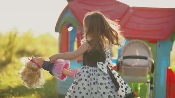 Маленькая девочка кружит вокруг куклы — стоковое видео
