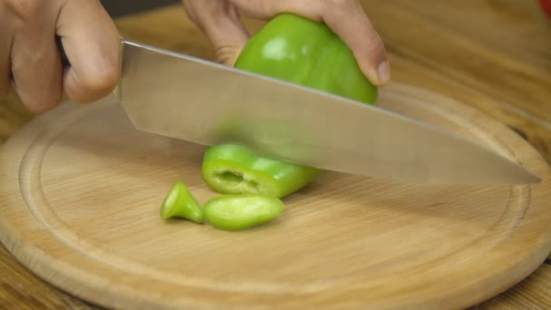 Нарезание зеленого перца на деревянной доске — стоковое видео