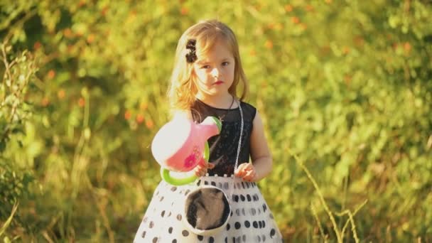 Girl with watering goes to get water — Stock Video