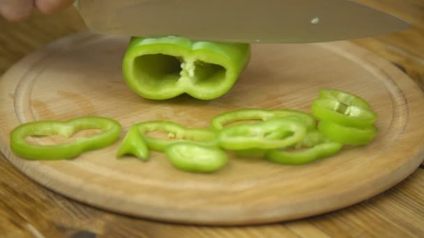 Rebanar pimiento verde en una tabla de madera — Vídeo de stock