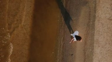 Kız sahilde yürüyor.