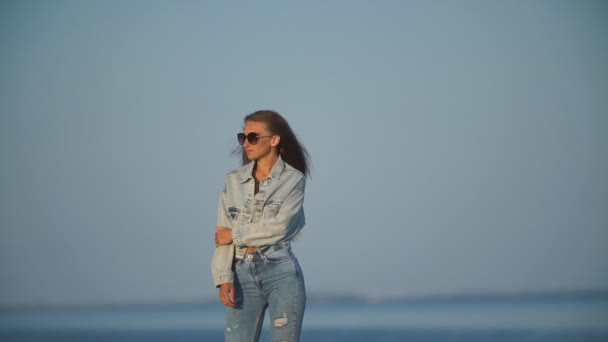 女孩在牛仔裤衣服在海洋的背景 — 图库视频影像