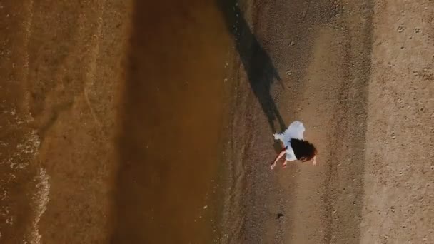 Дівчина гуляє вздовж пляжу — стокове відео