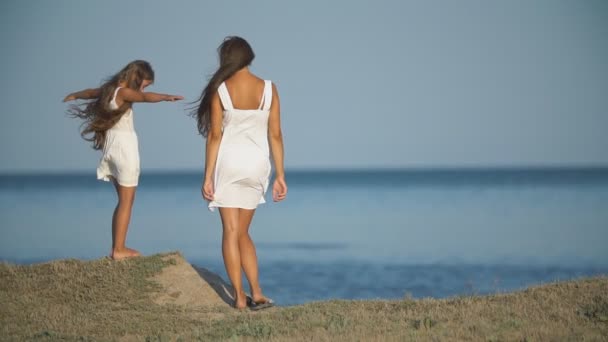 Mutter mit Tochter in weißen Kleidern am Meer — Stockvideo