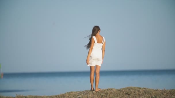 Chica en un vestido blanco cerca del mar — Vídeos de Stock